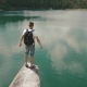 Young Active Man Widens His Hands On Rock Slope Upon Calm Mountain Lake Surface - VideoHive Item for Sale