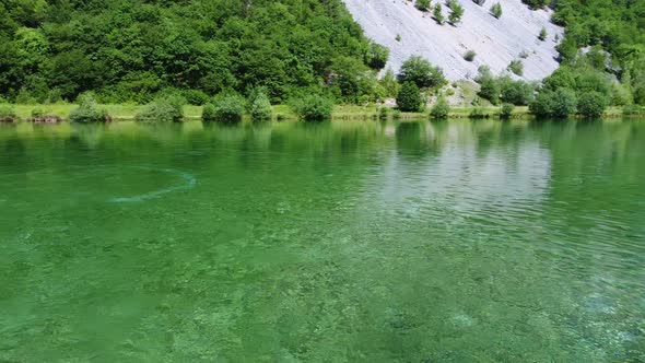 A wooden bridge in the middle of the calm and clear lake