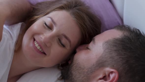 Pregnant Woman and a Man in White T-shirts Lying