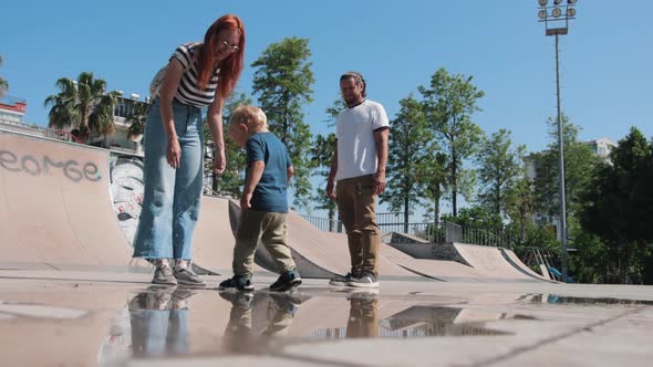 Family Spending Time with His Little Son in the Skatepark After Raining