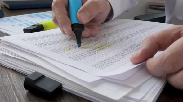 Closeup of Hands Making Notes on the Financial Report