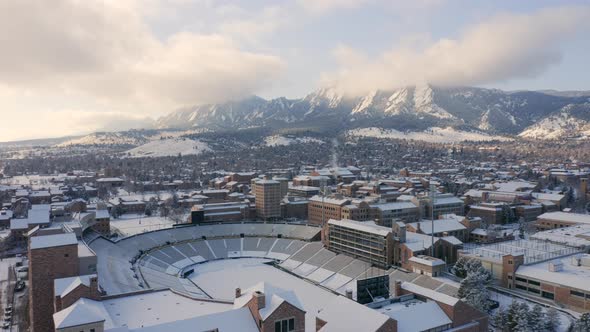 Aerial drone moving forward over University of Colorado Boulder campus covered in snow on a winter m