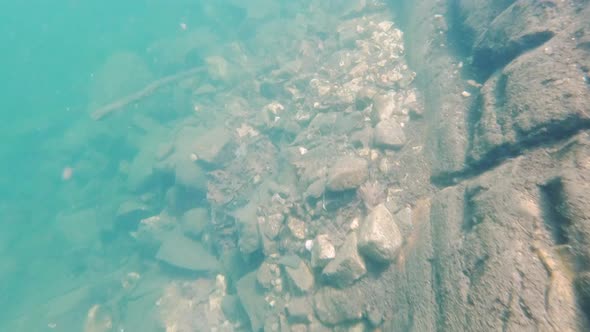 POV Dive to Bottom of Cliff under Blue Lake, Swim Back Up in Sun Rays Underwater