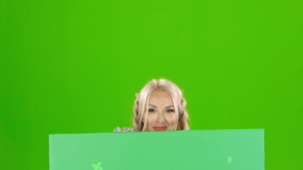 Bavarian Girl Looks Out From Behind a With a Glass Of Beer And Winking . Green Screen