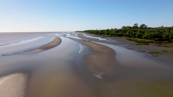 Slow wide forward aerial shot of sand banks by coast of La Plata River