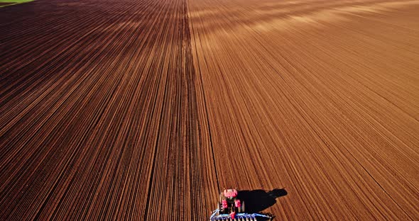 Plowed field with tractor, seeding soybeans