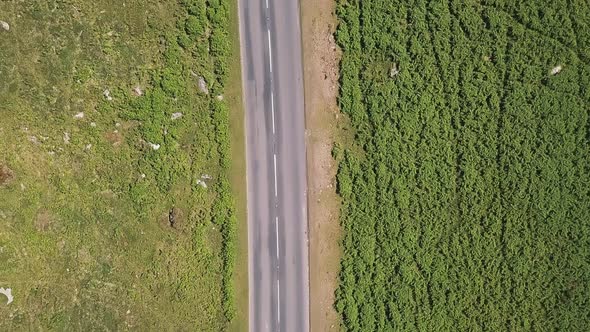 Drone footage; Cenital shot of a highway in Devon, UK. Green Scenery and cars.