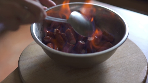 Chef In a Restaurant Kitchen Prepares Sausages