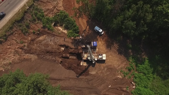 Drone Flying Down,workers Shipping Pipes In Truck With Blue Cabin By Crane In Sunny Summer Day