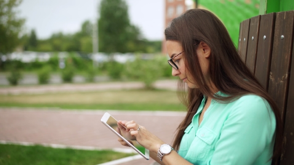 Elegant Young Girl Using The Mini-Tablet