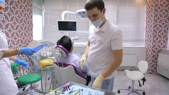 Assistant And Doctor Stand In Working Cabinet And Prepare For Further Procedures.