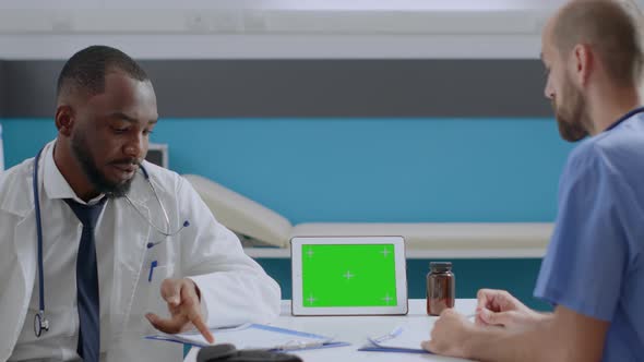 African American Physician Doctor Explaining Sickness Symptoms to Man Nurse