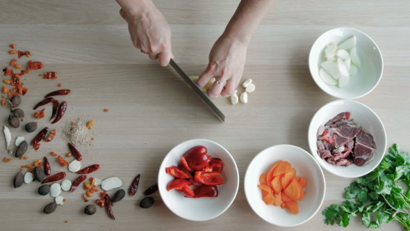 Top View Of Chefs Hands Chopping Ginger On Wooden Board