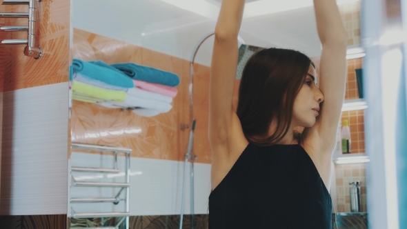 Young Brunette Girl Stretch In Front Of Mirror In Bathroom. Morning. Reflection