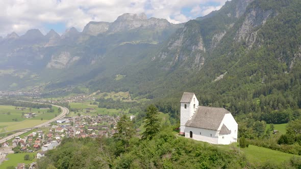 Circling around a little church on top of a mountain just at the edge of a cliff. In the back there