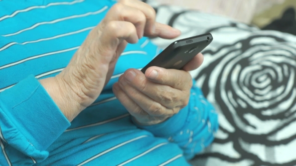 Hands Of The Old Woman And Smartphone
