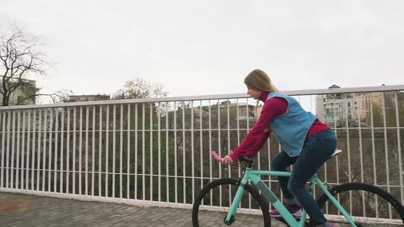 A Young Hipster Girl Riding a Fixed Gear Bike at City Centre Slow Motion