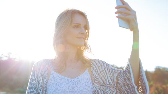 Beautiful Girl Making Selfie Enjoying the Sun in City Park