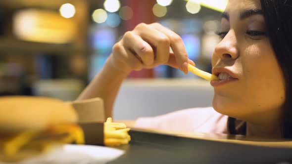 Excited Young Woman Eating French Fried Potatoes, Junk Food Pleasure, Meal