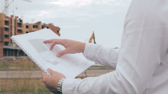 Unrecognizable Architect Looking At Blueprints At a Building Site.