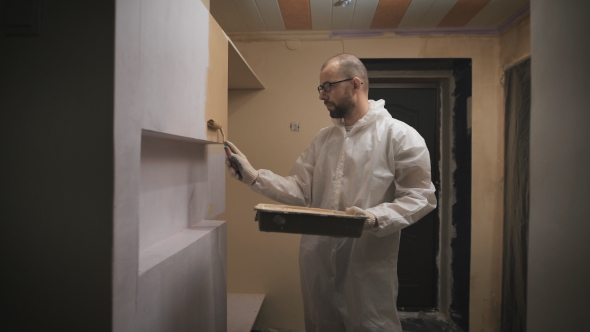 House Painter With Glasses And Beard Roller Paints The Wall.