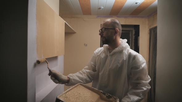 House Painter With Glasses And Beard Roller Paints The Wall.