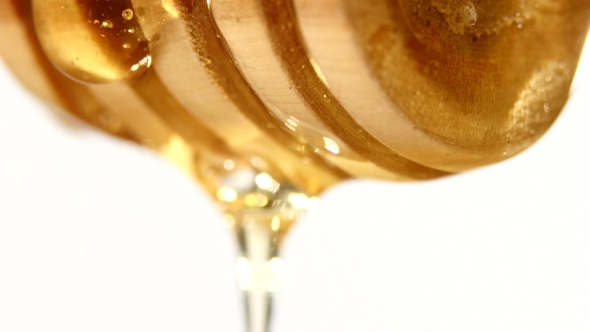 Honey Dripping From a Wooden Spoon, On White