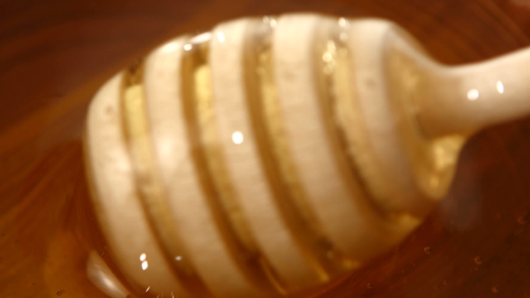 Using Spoon For Honey In Wooden Bowl, 