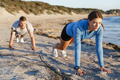Young couple doing push ups on ocean beach - PhotoDune Item for Sale