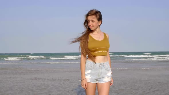 Sexy Young Girl with Long Hair Standing on the Beach