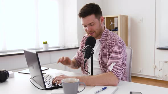 Happy Young Man with Laptop and Microphone at Home 