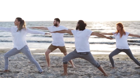 Group Of People Making Yoga Exercises On Beach 28