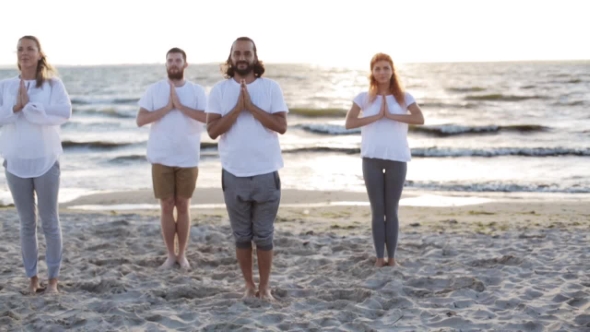 Group Of People Making Yoga Exercises On Beach 32