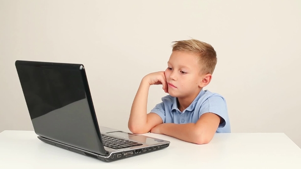 Cute Teen Boy Working On Laptop Computer Or Watching Video In Internet