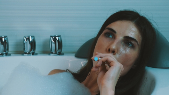 Girl Take Bath Full Foam In Bathroom. Smoke Electronic Cigarette. Exhale Steam