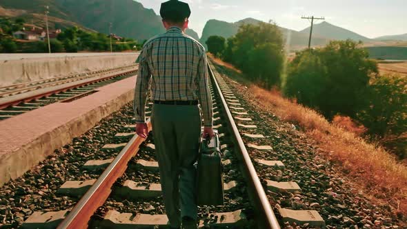Suitcase Walking Down Railroad Tracks