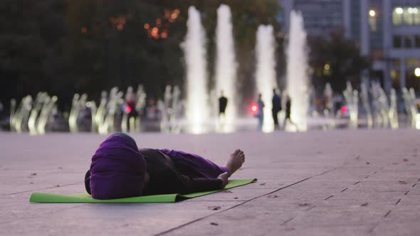 Muslim Islamic Woman Yogi Girl in Hijab Female Athlete Tired Lady Lies on Green Mat in City