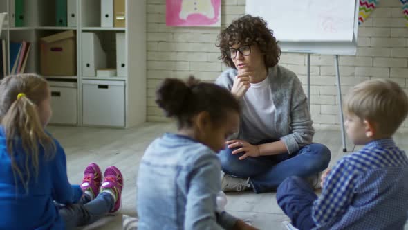 Female Teacher Speaking with Children in Kindergarten