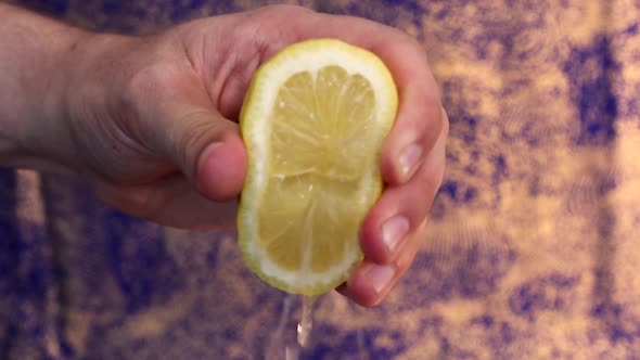 Squeezing a lemon to get the lemon juice out. Hand is giving maximum power to squeeze it out.
