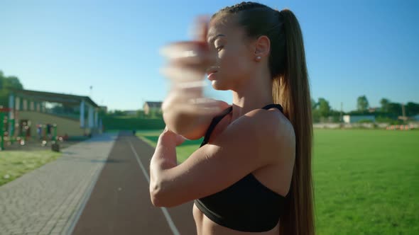 Girl Warming Up Upper Body at Stadium in Morning