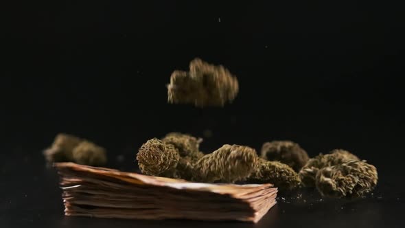 Marijuana buds falling near money bills over a dark background. Cannabis and illegal business