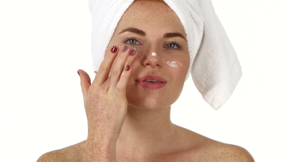 Beautiful Young  Woman Applying  Cream On Face, Bathroom