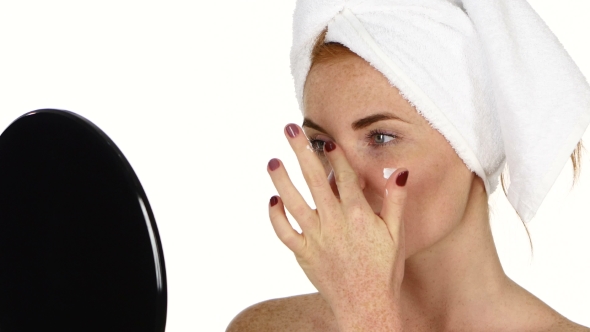 Young Woman Applying Face Cream, Bathroom