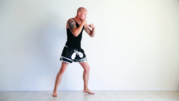 Muscular Kickbox Or Muay Thai Fighter Punching In White