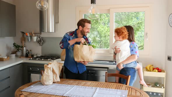 Family unpacking groceries in kitchen