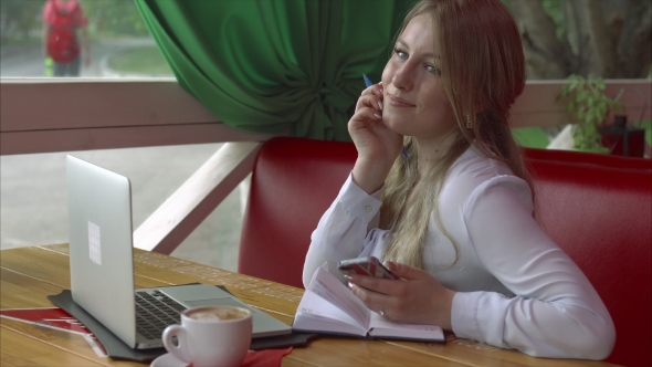 Business Woman In a Cafe Working With Smartphone Laptop And Notebook