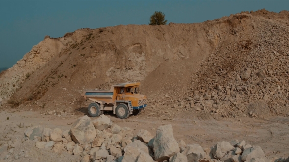 Mining Truck is Driving an Iron Ore Mine Loaded with Ore