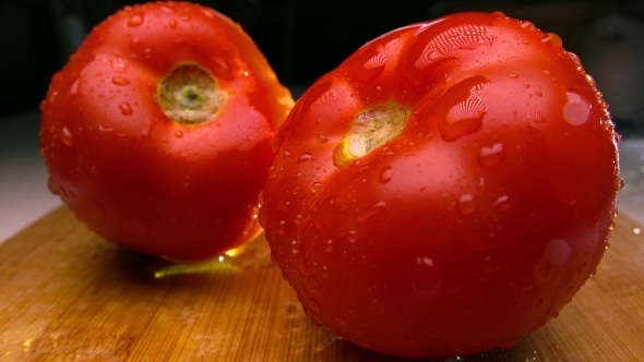 Red Tomatoes On Wooden Cutting Board Being Sprayed With Water