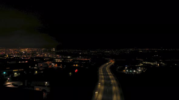 Aerial night view hyperlapse flying Reykjavik colourful illuminated city street Iceland freeway pull
