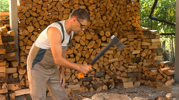 Young Man Lays On Chopped Wood In The Woodpile